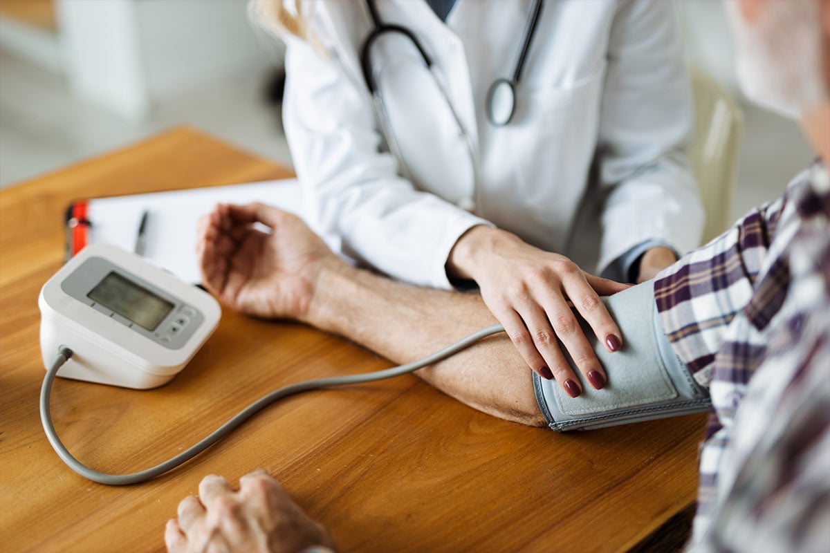 A doctor checking their patient's blood pressure